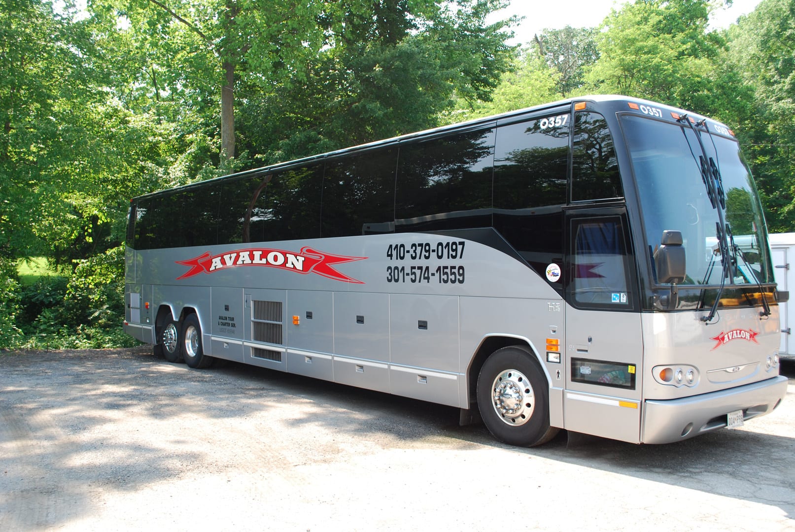 Left Side View of the Avalon Bus with a Phone Number